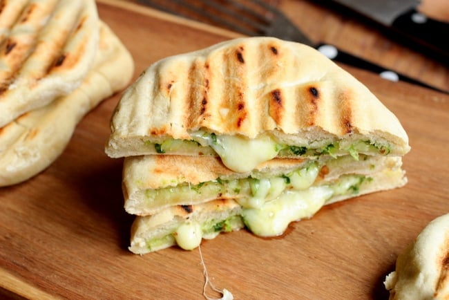 Stack of Mozzarella and Pesto Grilled Naan Bread on wooden board.