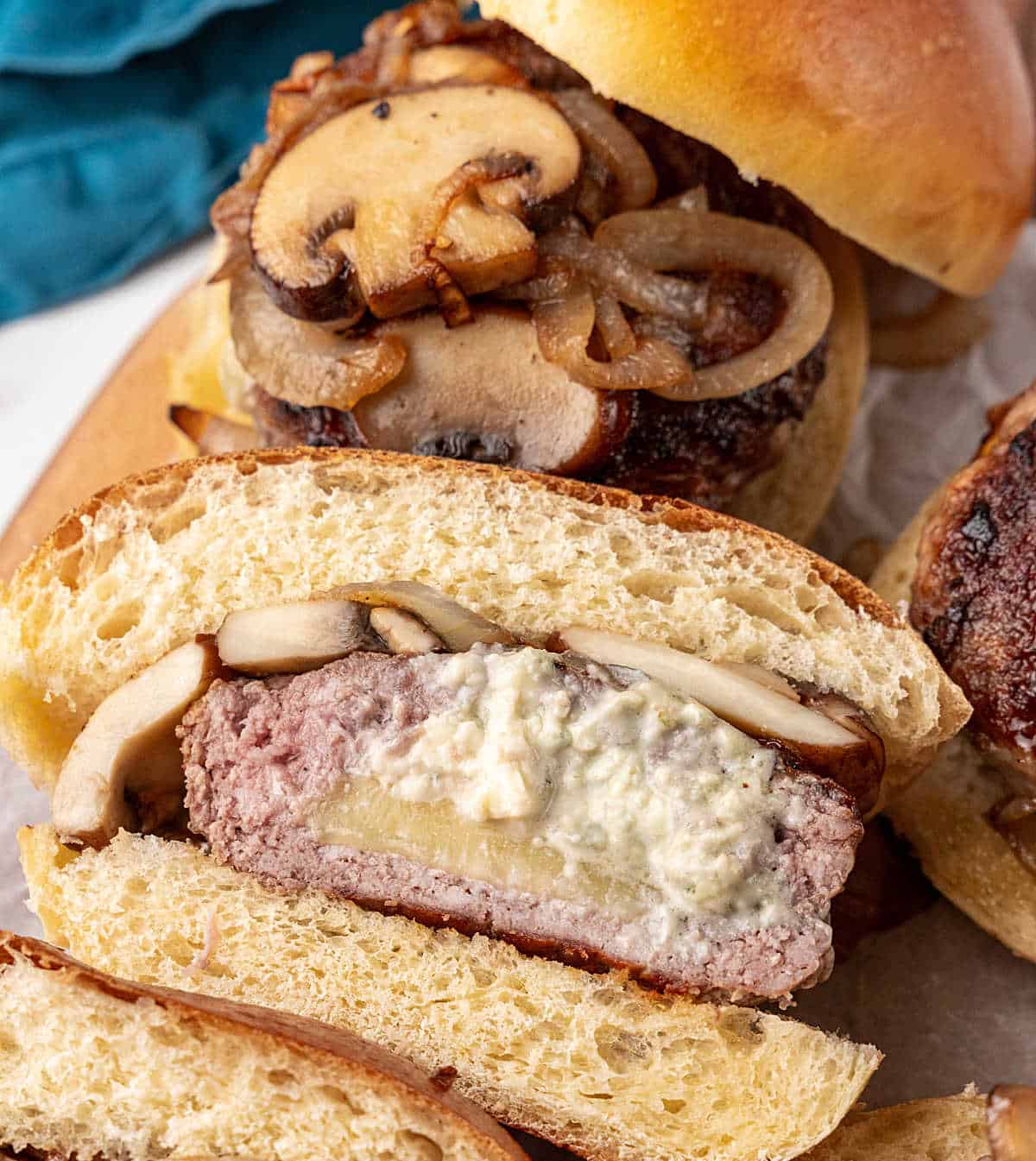 Halved blue cheese stuffed hamburger and bun, mushroom garnish.