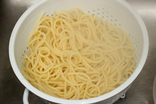 White colander with steamy just cooked spaghetti