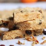 Close up image of three raisin shortbread pieces stacked on white paper.