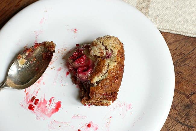 Easten raspberry roll on a white plate with a silver spoon. 