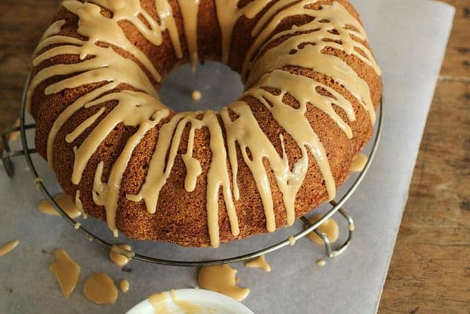 Whole Brown Butter Cake dripping with Coffee Glaze on wire rack, parchment paper