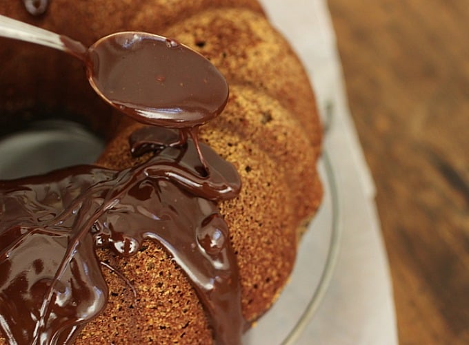 Pouring chocolate glaze over a bundt cake.