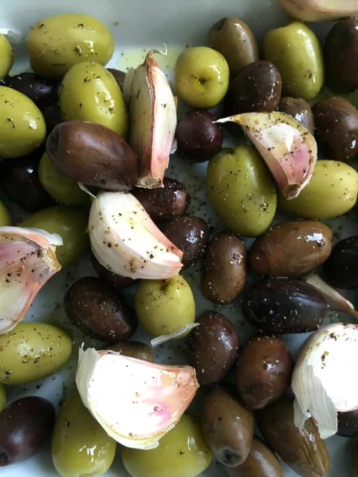 Whole green and black olives with unpeeled garlic cloves