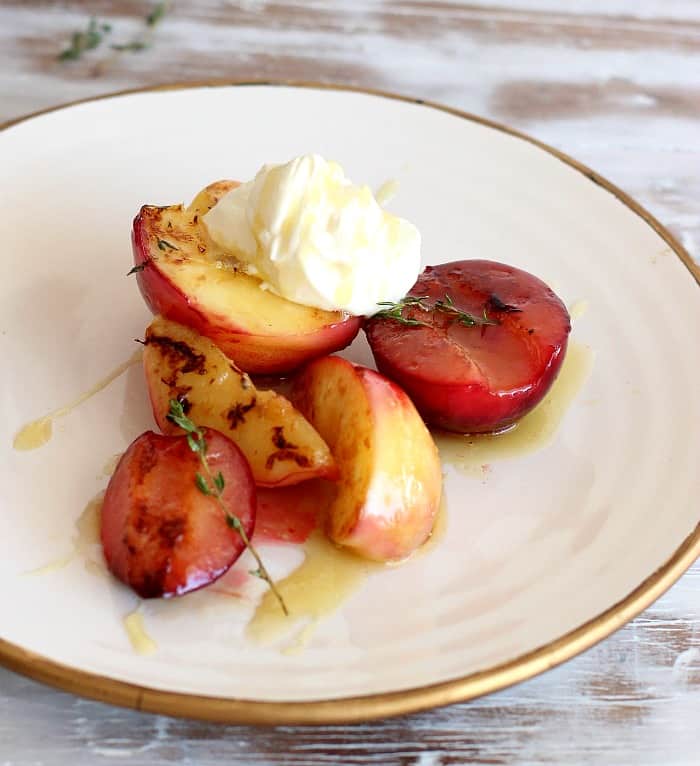 Honey Stone Fruit with thyme, cream and olive oil on white plate