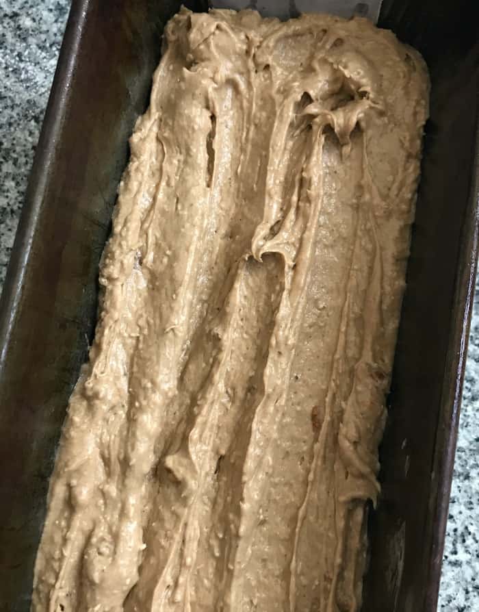 Metal loaf pan with coconut pecan cake batter. 