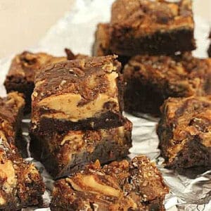 Stacked pieces of swirled brownies on aluminum foil.