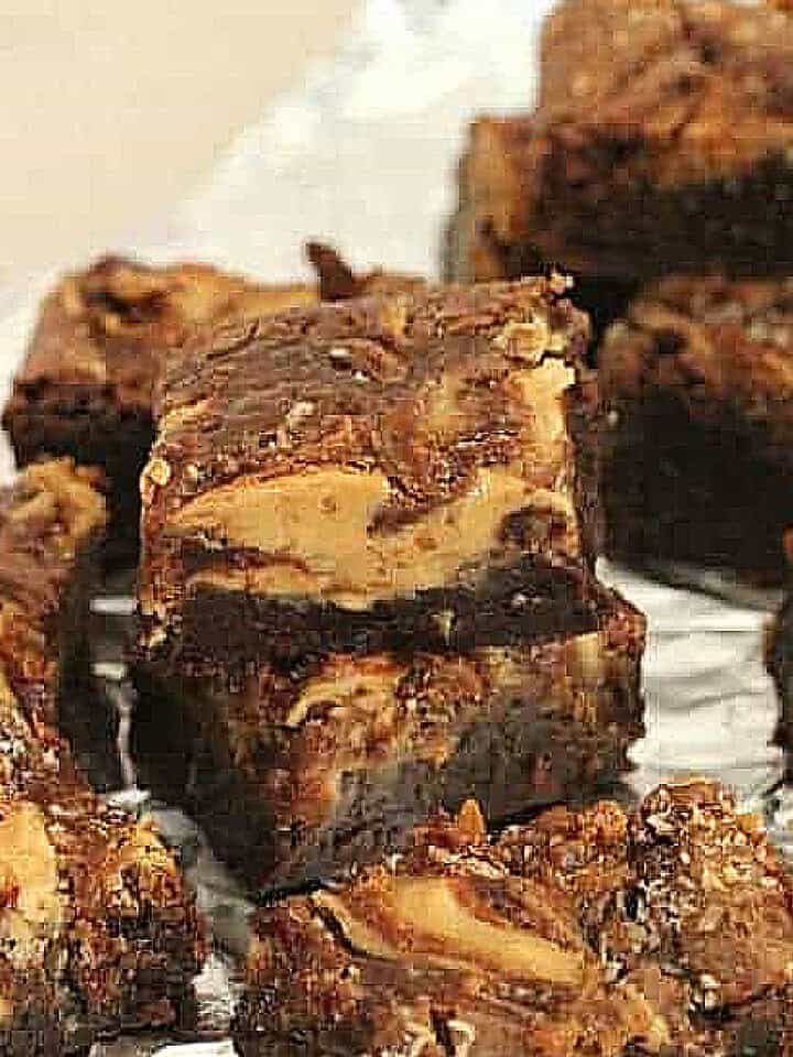 Stacked pieces of swirled brownies on aluminum foil.