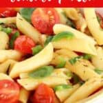 Red, green and white text overlay on bowl of short pasta with tomatoes and jalapeños.