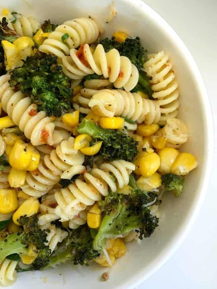 white bowl with broccoli corn harissa pasta bowl