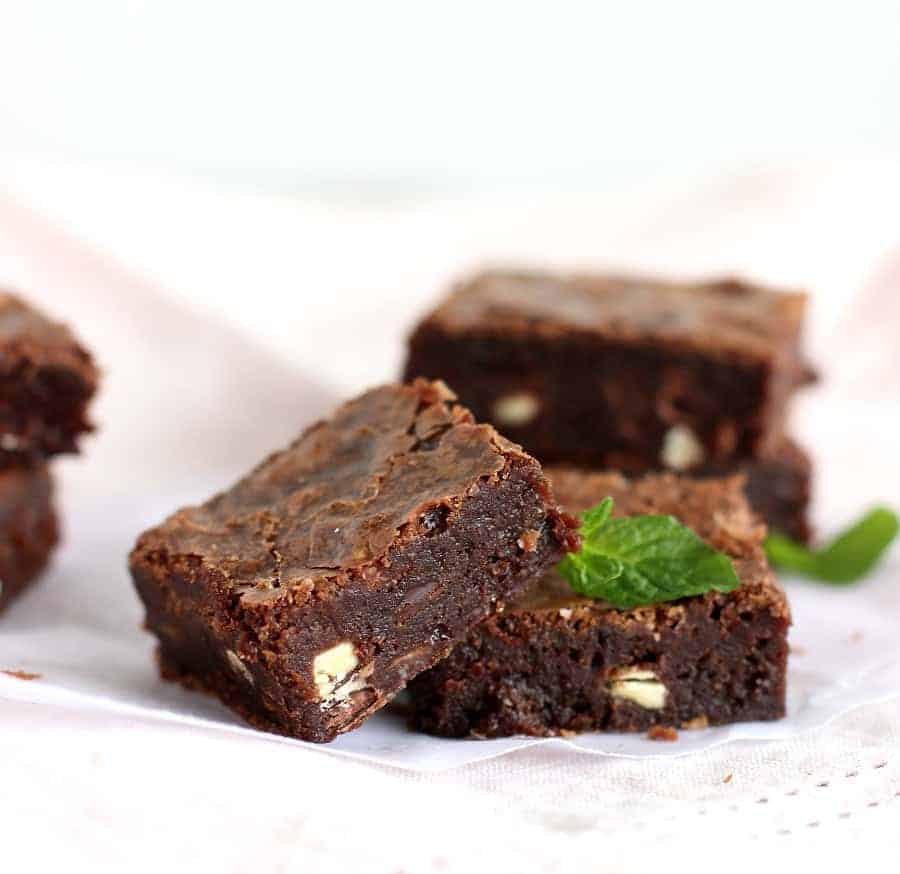 Squares of Fudgy chocolate mint brownies, mint leaves, pink napkin