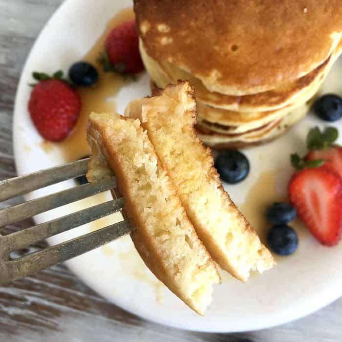 Fork with piece of buttermilk pancakes.