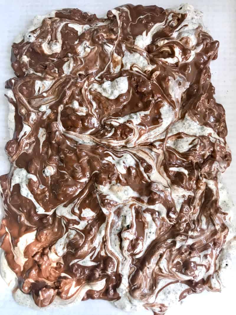 Marbled melted white and dark chocolate on spread on parchment paper