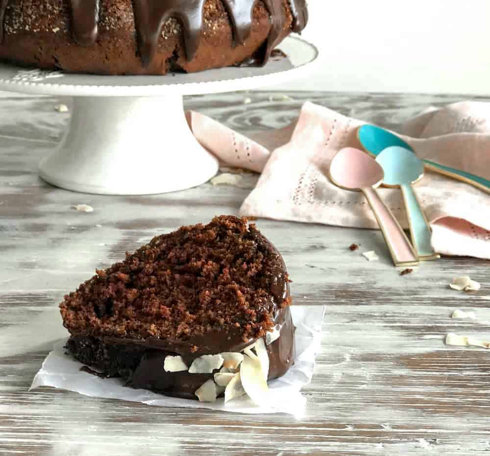 plak chocolade kokoscake, wit oppervlak, cake op taartstandaard, lepels