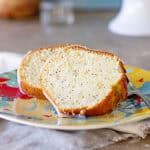 Slices of poppy seed bundt cake on a colorful plate. Gray background.