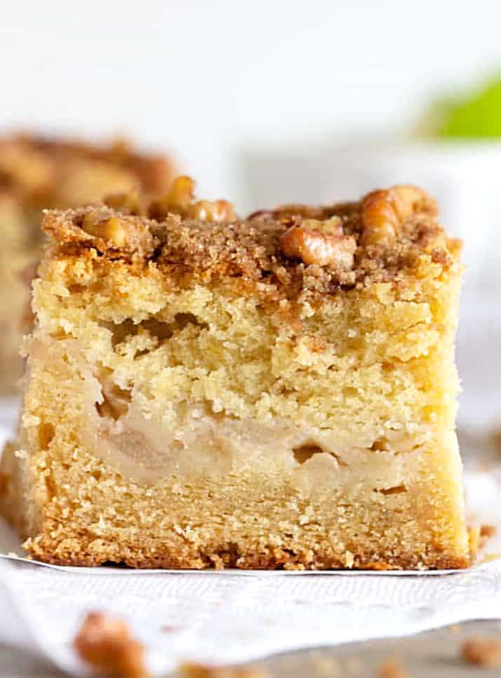 apple coffee cake Close-up of Apple cake square with walnut crumble on white napkin