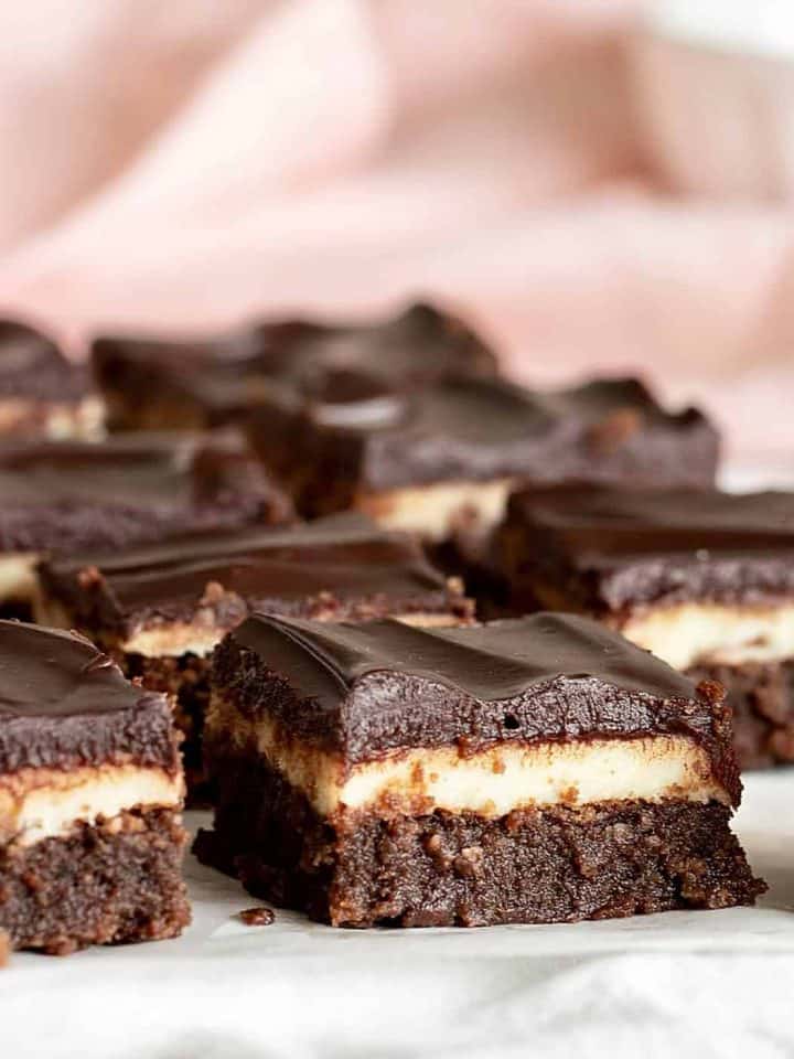 Squares of chocolate brownie Cake on white surface, pink background