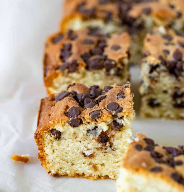 Squares of vanilla cake with chocolate chips on parchment paper