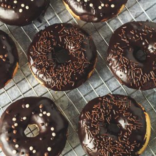 Chocolate covered vanilla doughnuts on a wire rack