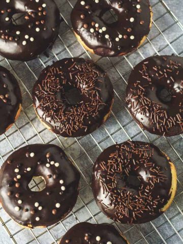 Chocolate covered vanilla doughnuts on a wire rack