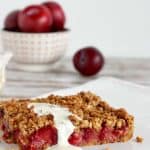 Plum tart with cream, bowl of plums, text banner