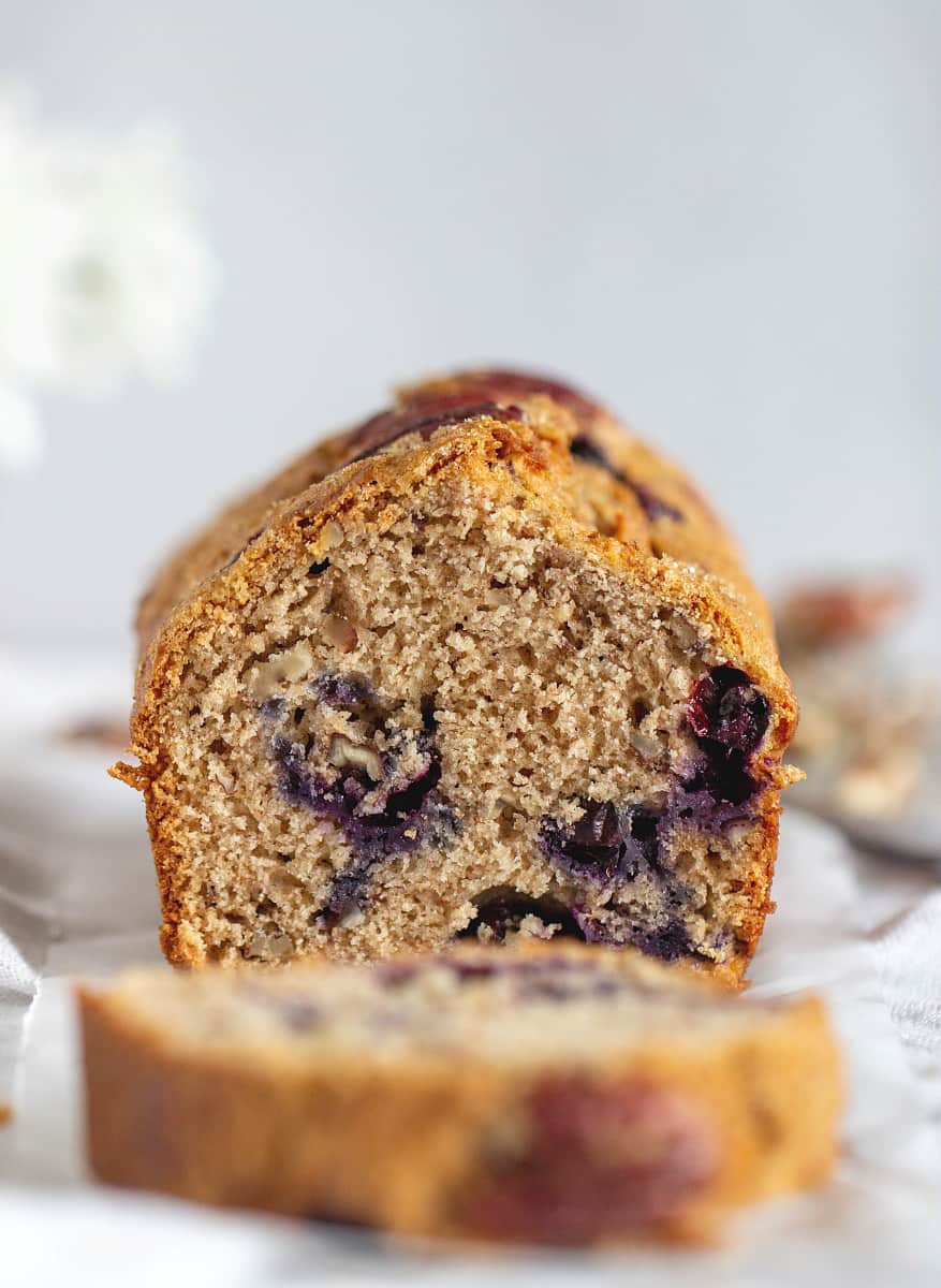 Cut Loaf of blueberry applesauce cake, blurred slice in front