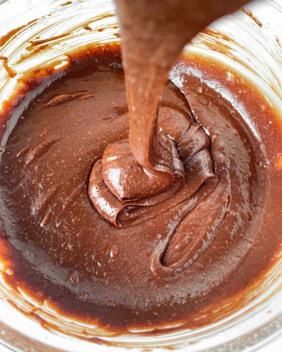 Chocolate brownie batter in a glass bowl. Close up view.