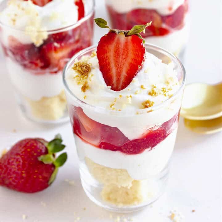 Close up glasses with strawberry cream trifles. White background.