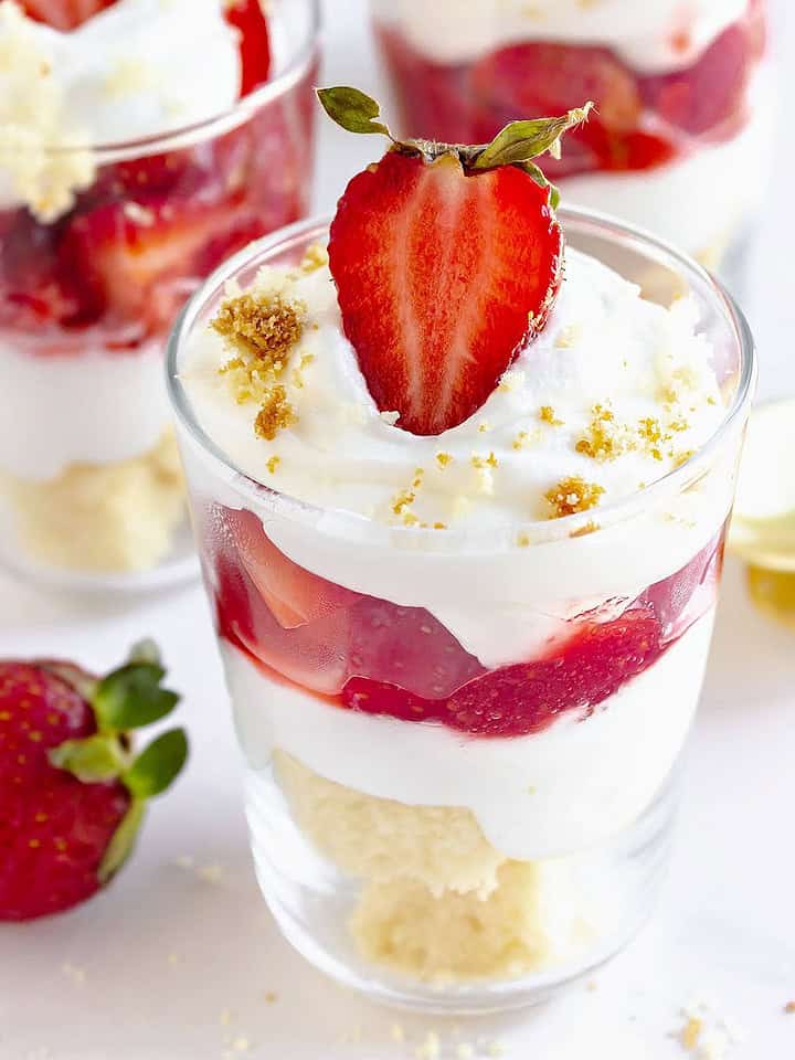 Close up glasses with strawberry cream trifles. White background.