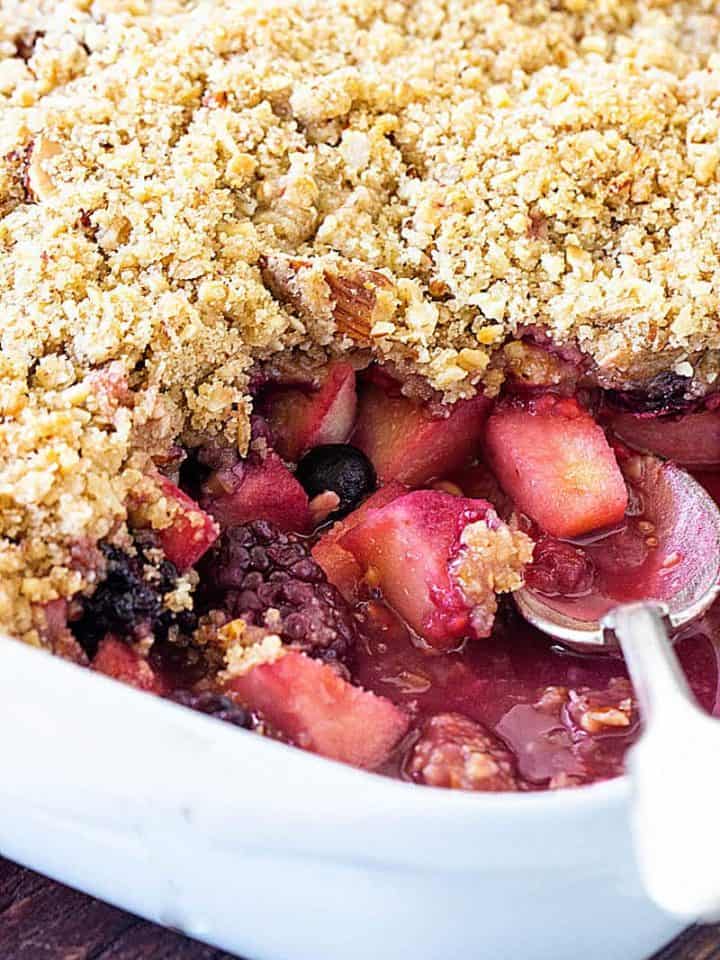 White pan with apple berry crumble, spoon