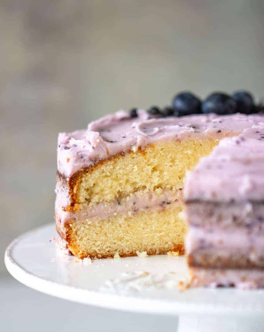 Cut lemon blueberry cake on white cake stand