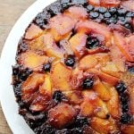 Partial overview of upside down cake on a white plate.