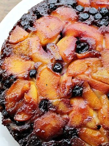 Partial overview of upside down cake on a white plate.