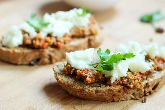 Walnut bread with tomato pesto and goat cheese on wooden board
