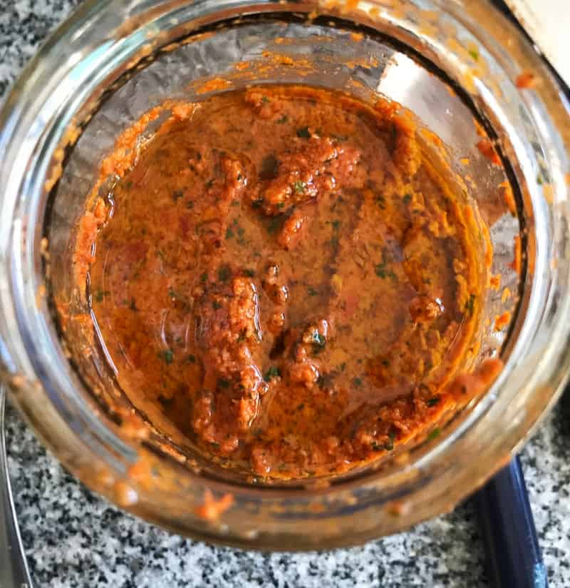Jar with sun-dried tomato pesto and olive oil