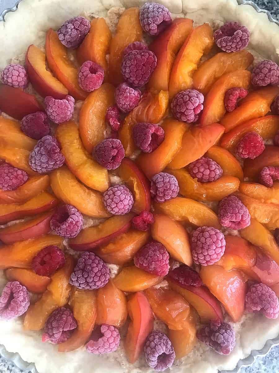 Unbaked pie crust filled with apricots and raspberries