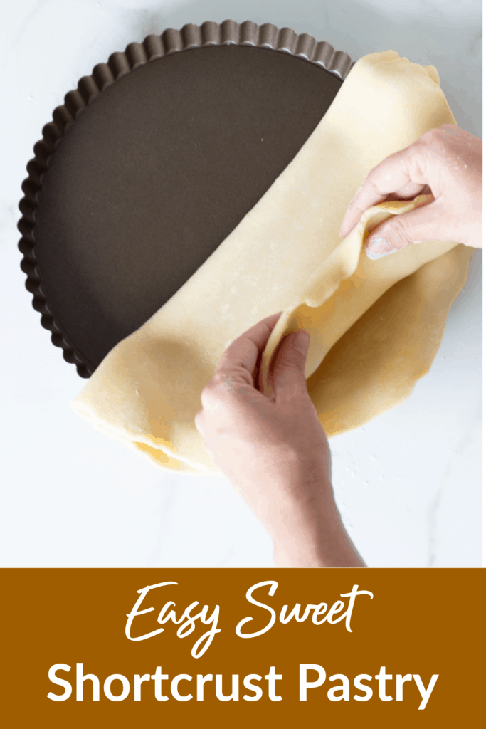 Hands lining pan with sweet shortcrust pastry