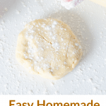 Ball of pie crust on white surface, hand sprinkling flour, rolling pin