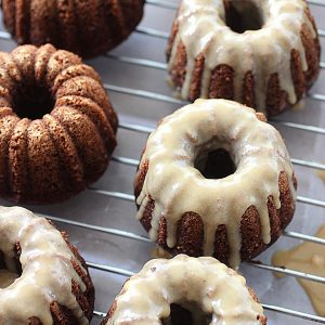 Glazed chocolate Kahlua cakes on a wire rack with parchment paper below.