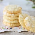 Stack of lemon crinkle cookies, white cloth with color dots