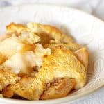 White bowl with serving of pear cobbler, white cloth