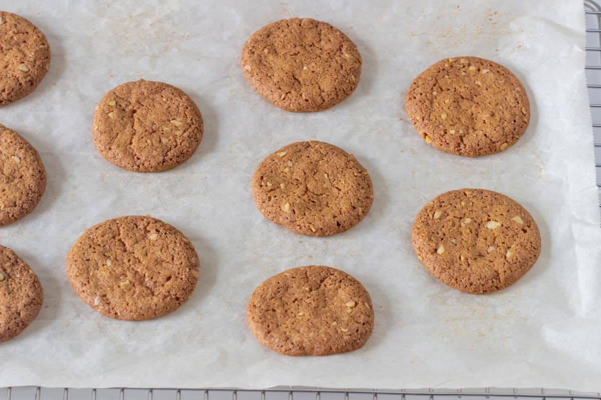 Baked walnut cookies on white parchment paper.