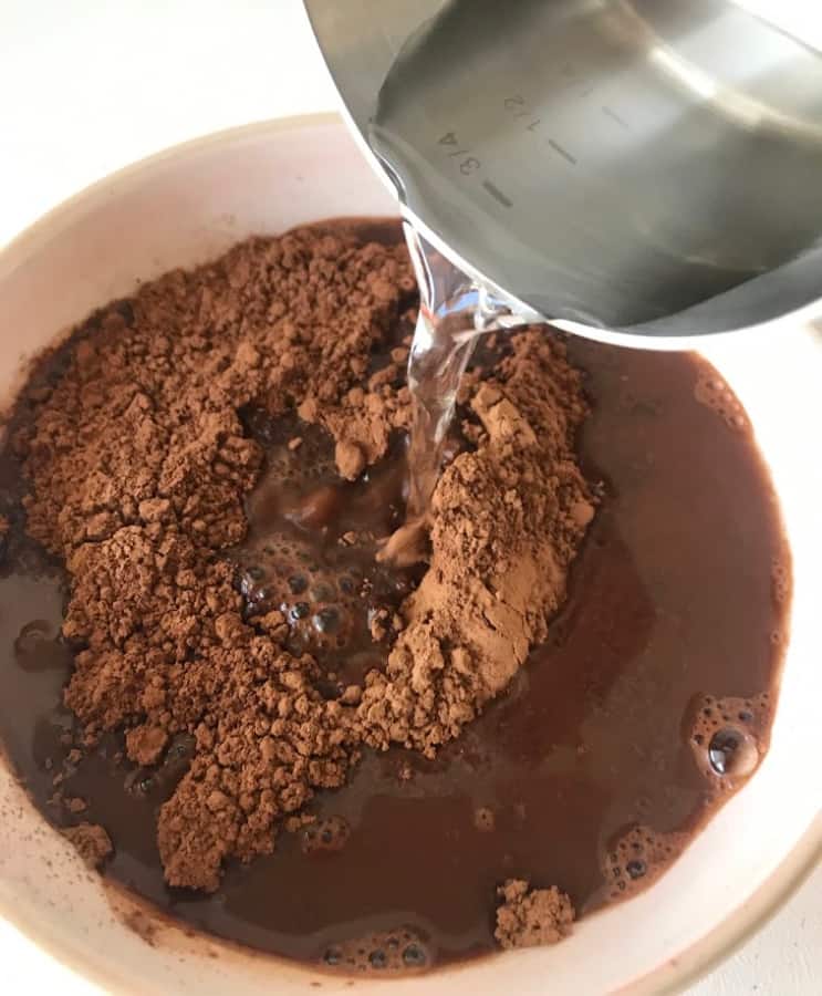 Pouring hot water into bowl with cocoa powder