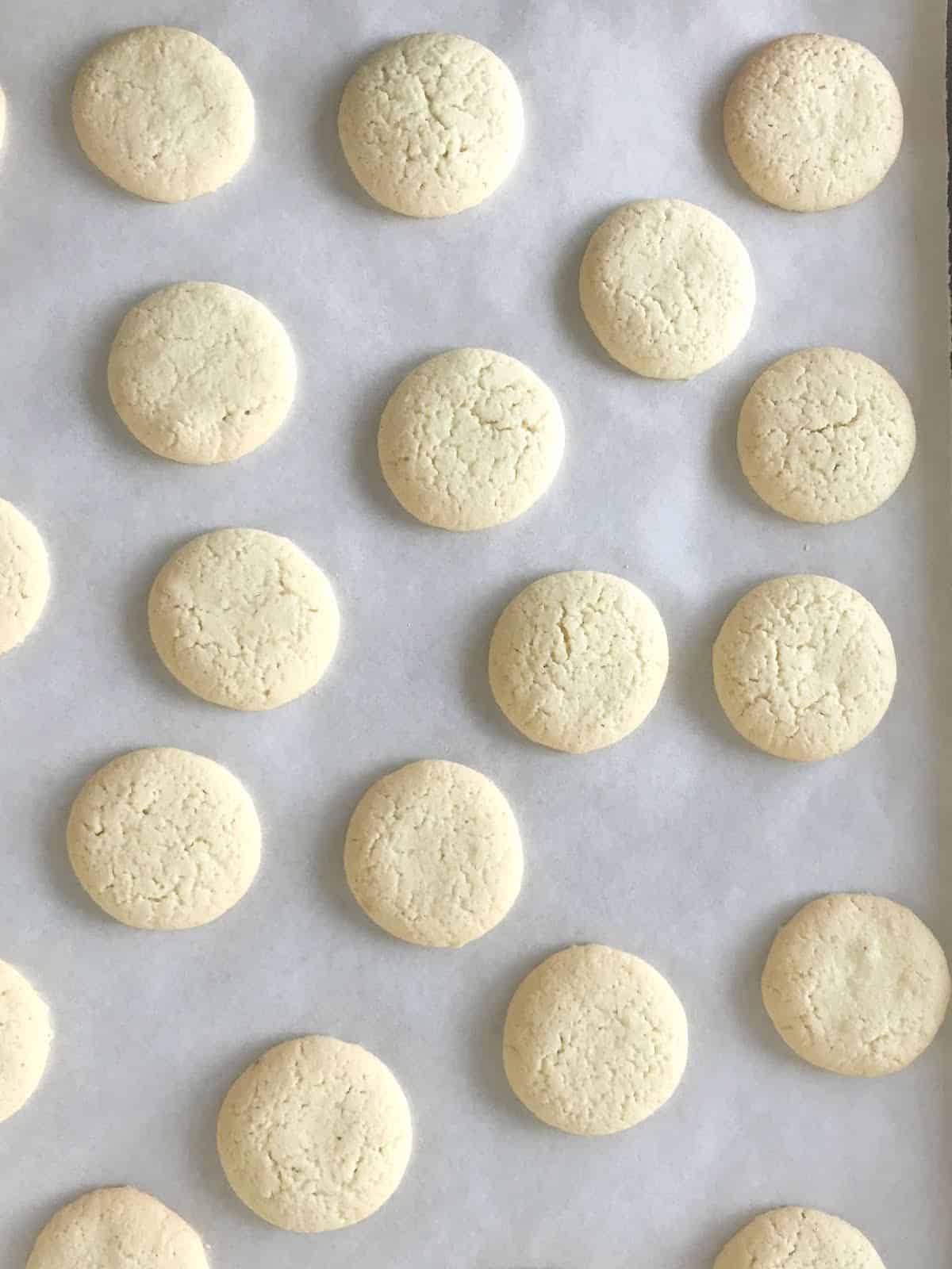 Baked cornstarch cookies on white parchment paper.