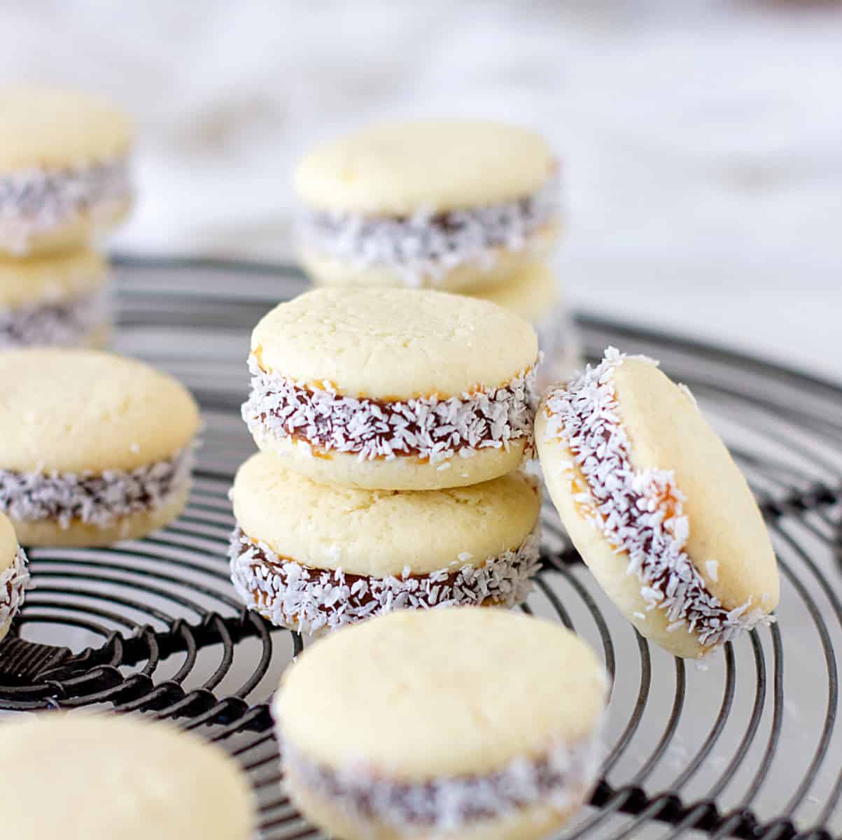 Several stacked alfajores on grey wire rack