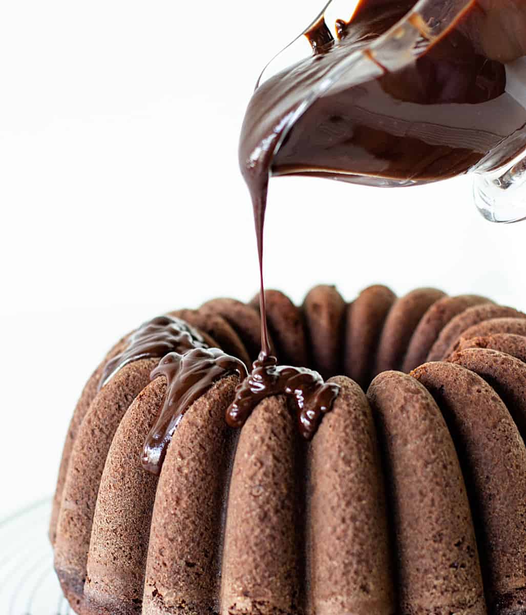 Ganache being poured over chocolate bundt cake