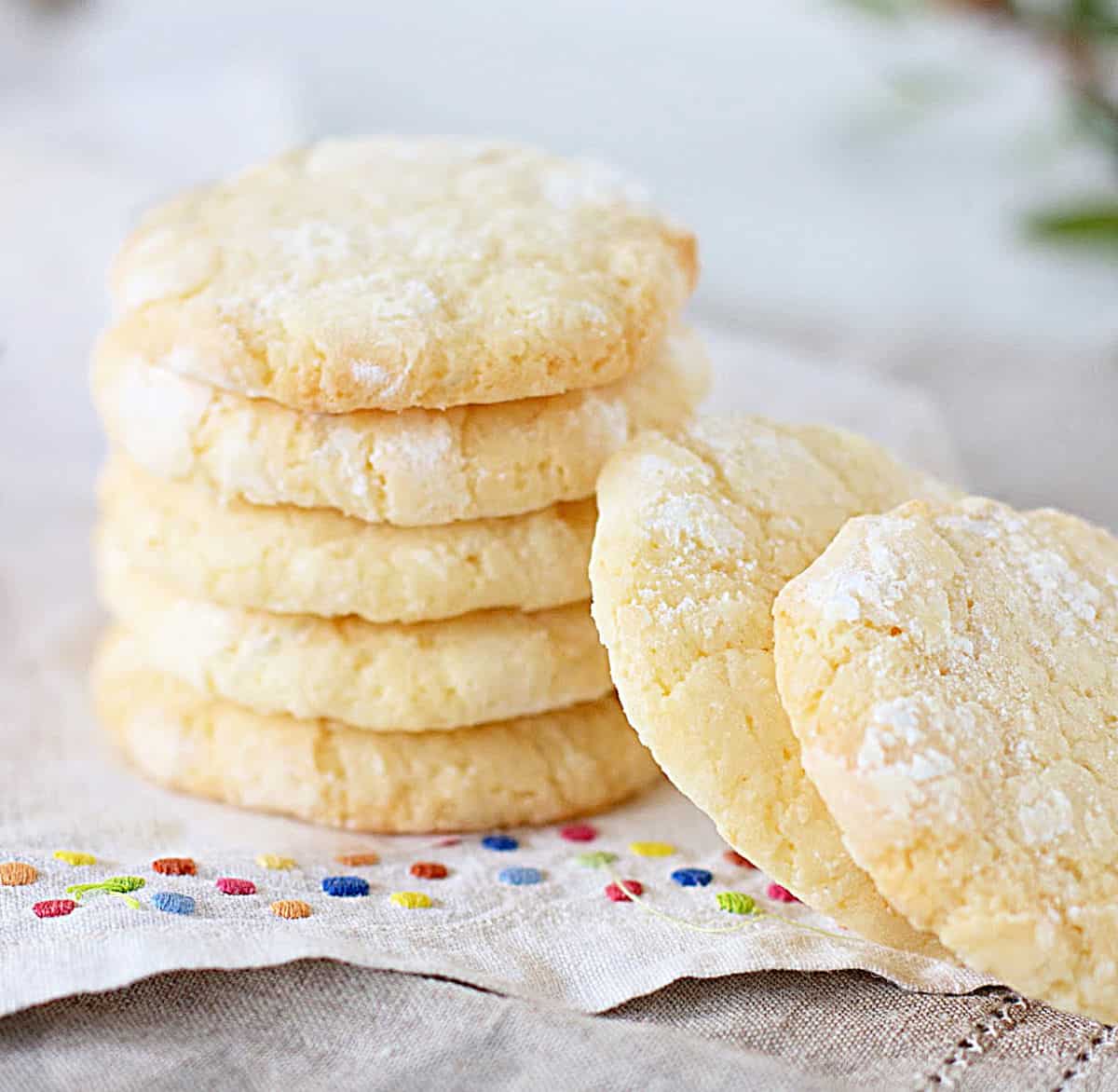 White cloth with colored dot with stacked lemon crinkle cookies.