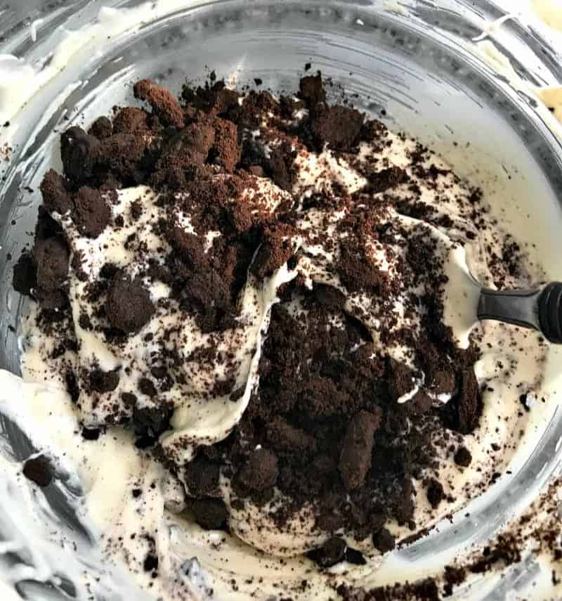 Mixing melted white chocolate with chocolate cookie crumbs