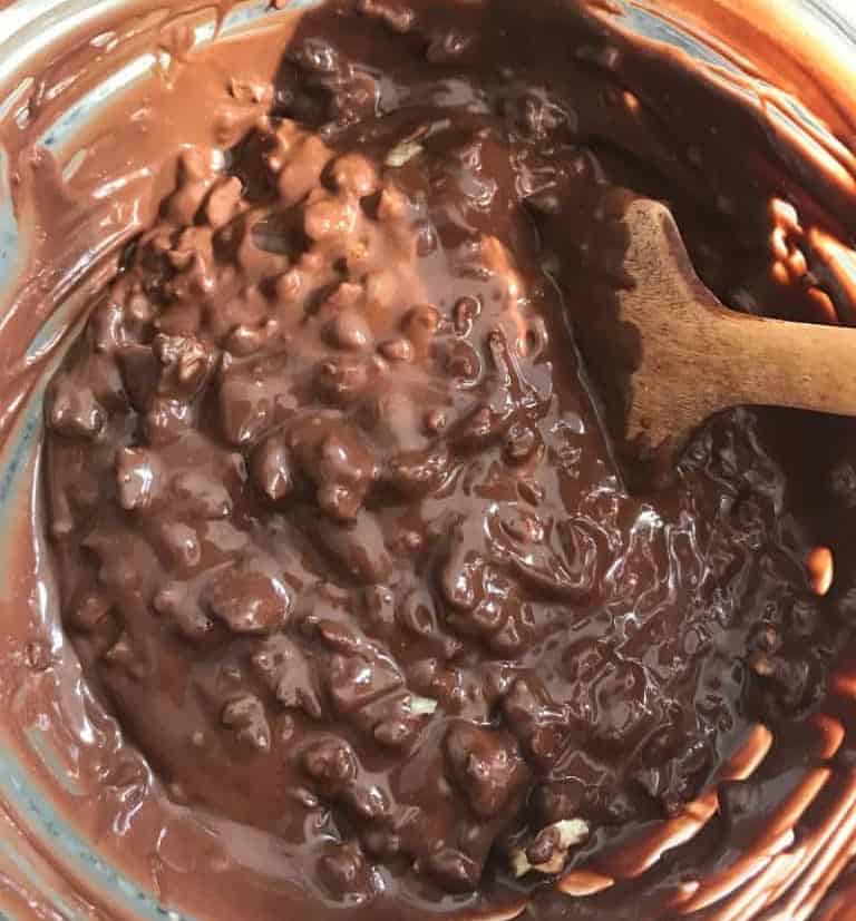Mixing melted milk chocolate with chopped walnuts