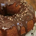 Partial image of whole glazed chocolate bundt cake on wire rack